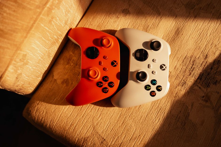 Dos controladores de juego sobre una superficie de madera iluminada por la cálida luz del sol, ideal para temas de juego.