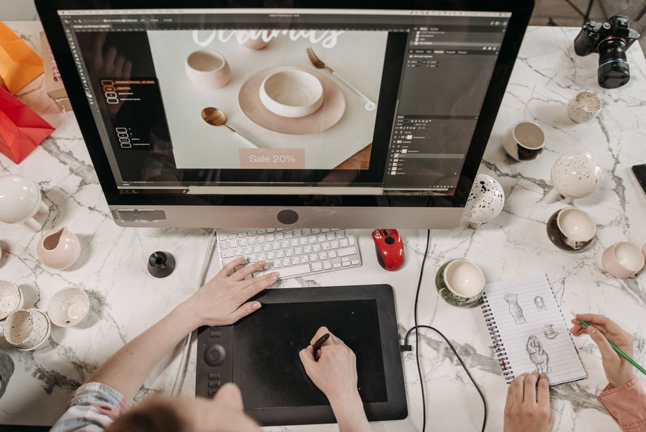Vista aérea de un espacio de trabajo creativo con herramientas de diseño y bocetos visibles, ideal para el trabajo en equipo y la colaboración.