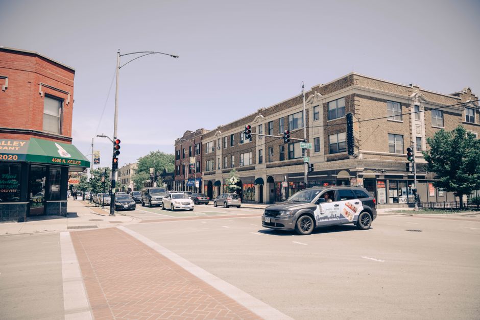 Escena urbana de una intersección transitada en Chicago con coches y edificios de ladrillo.
